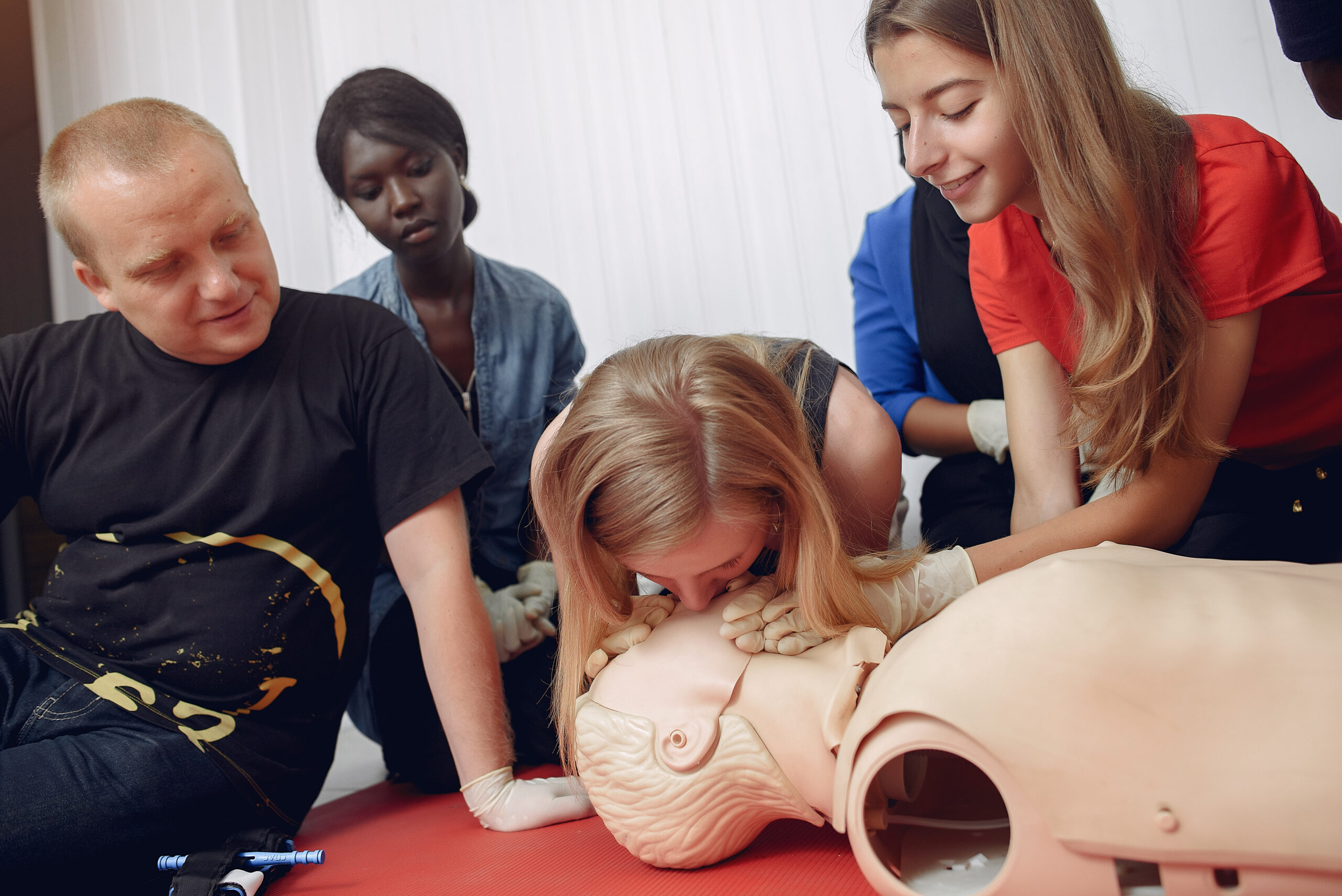 People are practicing medicine.Men and women are learning how to properly provide first aid.